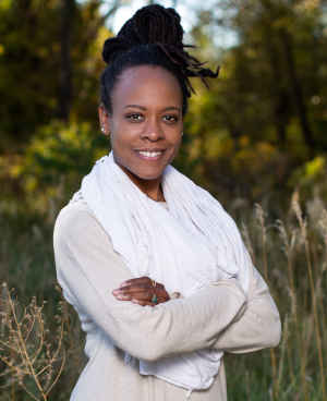 Therapist Anastasia Mitchell's headshot outdoors wearing a beige top and white scarf