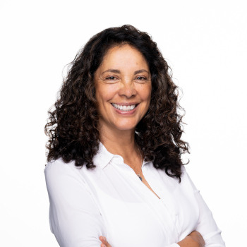 Headshot of therapist Brenda Lucero wearing a white blouse, smiling.