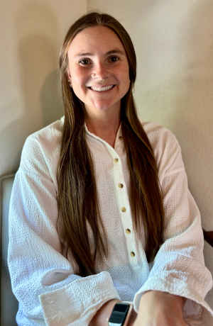 Therapist Lindsay Sugo's headshot indoors wearing a white top