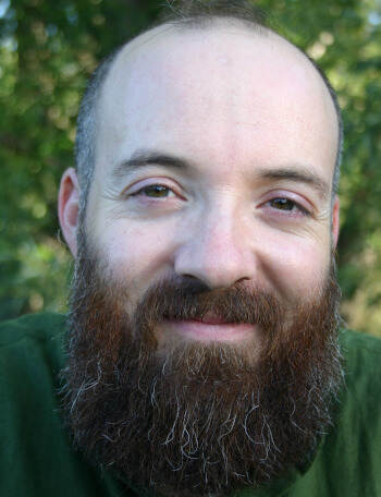 Photo of provider Tobias Gale, smiling, wearing a green sweater, outside.