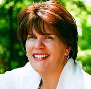 Headshot of therapist Mary Aragon, outside smiling, wearing a white blouse