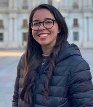 Headshot of Therapist Nina Respeto, standing outside, smiling, wearing a black jacket