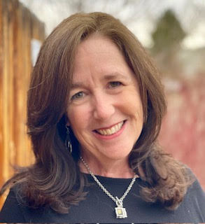 Headshot of therapist Stephanie Luther standing outside, smiling, wearing a black shirt