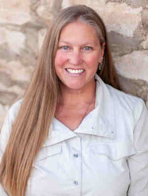 Photo of provider Jennifer Kniffin-Turner, standing outside, wearing a white button up shirt, smiling.