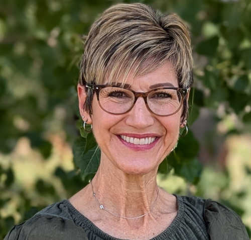 Photo of therapist Andrea Jegier, standing outdoors, smiling.