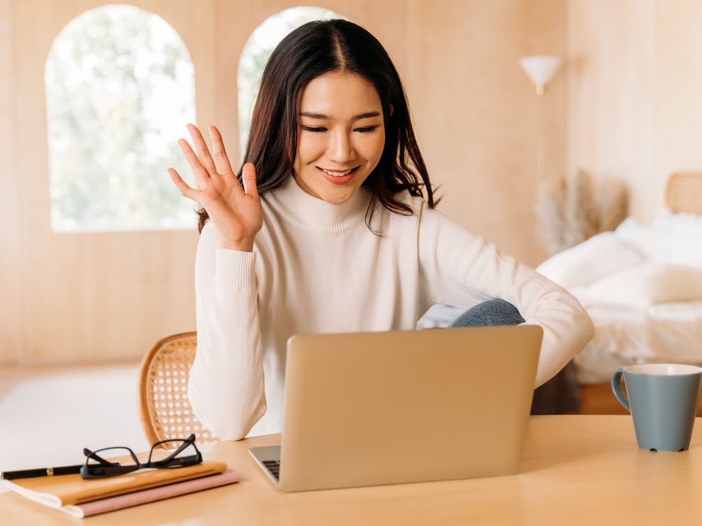 Person smiling and waving at computer, About Westside Behavioral Care