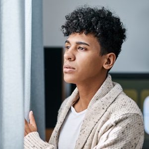 Person looking out of a window, depressed